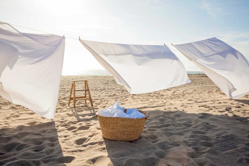 Lakan som blåser i solen på en strand.