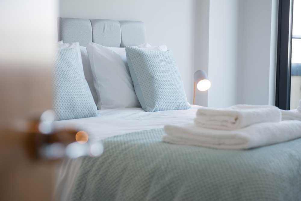 Renbäddad säng med ljusa lakan.